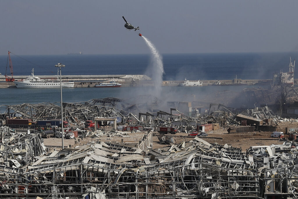 Un helicóptero del ejército arroja agua en el lugar de la explosión masiva del martes que golpeó el puerto de Beirut, Líbano, el miércoles 5 de agosto de 2020.